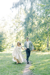 Fototapeta premium The wedding couple is walking along the Park. Photo shoot in the European style in nature.