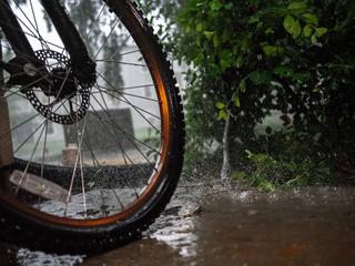 Fototapeta na wymiar Wet bike left out in the rain for a high action shot with the rain drops splashing against the ground.