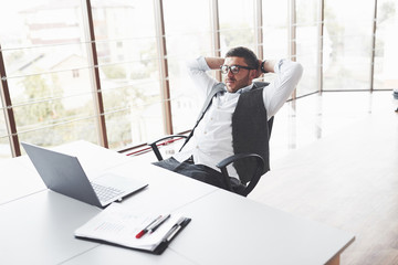 A difficult day appeared. Young businessman having a rest while sitting in chair in the clean room...