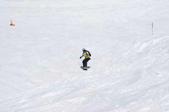 Snowboarder downhill on snowy ski slope at high winter mountains