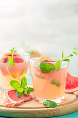 Fresh pink alcoholic cocktail with grapefruit, ice and mint