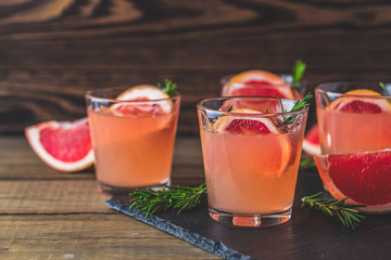 Alcoholic cocktail with grapefruit drink glass on a black stone board