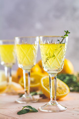 Liqueur limoncello with pieces of lemon and rosemary herb