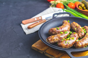 Fried sausage in a frying pan, with herbs and spices