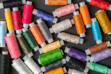 bunch of colorful sew threads lay on dark background isolated d