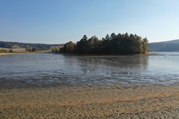 Photo of dry drained breeding pond with mud. Carps, perch, roach and other fish bodies on the shallow ground.