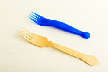 Disposable plastic and wooden forks on a white background