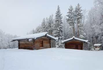 Fototapeta na wymiar Two old wooden barns in North Russia