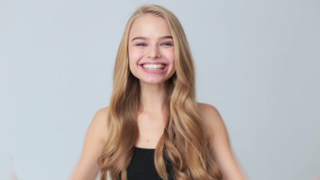 Young pretty surprised woman with opened mouth standing with open palms