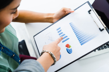 Young coworker woman making business discussion in modern home office. Teamwork people concept. Casual businesswoman pointing showing business data chart to colleagues