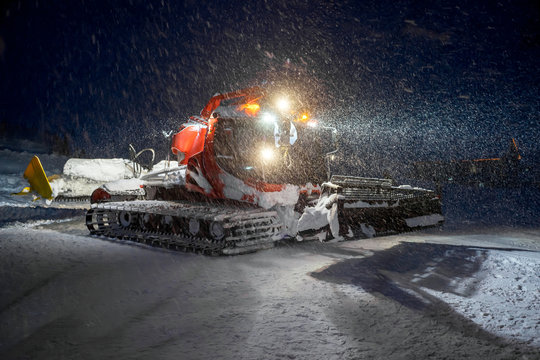 Snowcat preparing a slope at night in high mountains at skiing resort of the North Caucasus Elbrus