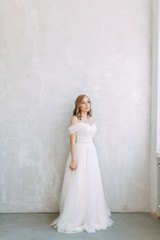 Fototapeta na wymiar Fees in the interior Studio in the European style. The bride in a white wedding dress.