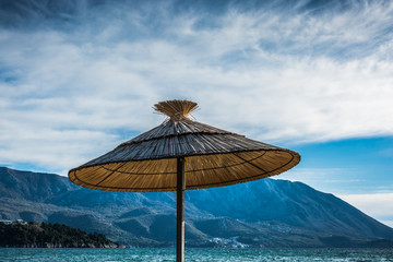 Thatch sun umbrella on sea and mountain background - 244249176