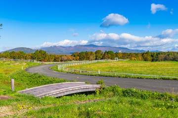宮城栗駒高原の牧場と紅葉の栗駒山と歩道のアーチの橋