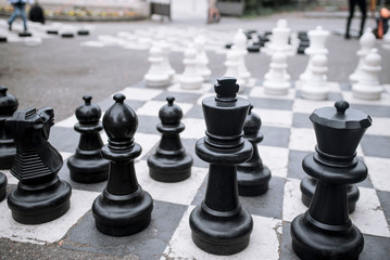 chess board with black and white figures outdoors for playing
