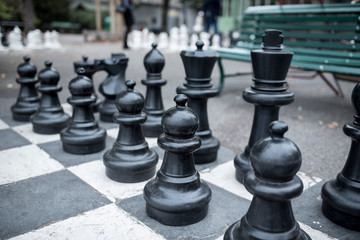 chess board with black and white figures outdoors for playing