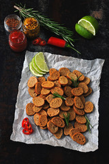 Obraz na płótnie Canvas Rye crackers with spices on paper. Croutons with rosemary, lime and chilli. Vegan snack