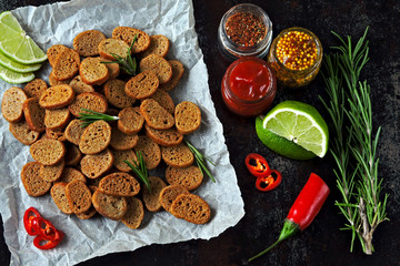 Rye crackers with spices on paper. Croutons with rosemary, lime and chilli. Vegan snack