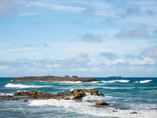 Great view of the sea, a little island and a boat on a beautiful windy day at Condado beach, San Juan, Puerto Rico