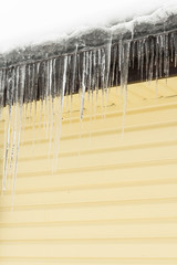Icicles hang from the roof of a private house in winter