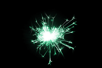 Fototapeta premium Low light photo of bengali fire isolated on black background with blue toning. A lot of light and sparks. Underexposed photo.