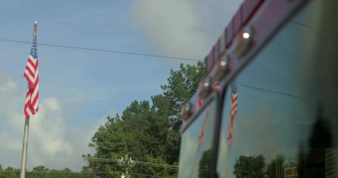 Reflection of American flag in firetruck windshield