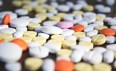 Colorful pills on wooden background.