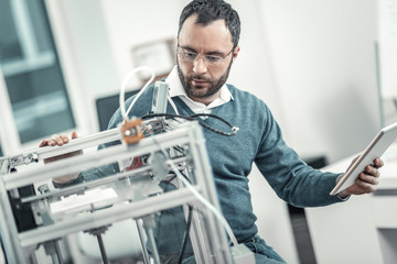 Serious professional adult engineer testing 3d printer - Powered by Adobe