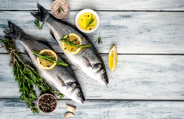 Fresh fish sea bass. Sea bass raw fish with ingredients spices and herbs on wooden background . Top...
