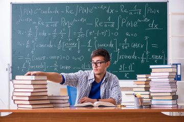 Young male student studying math at school