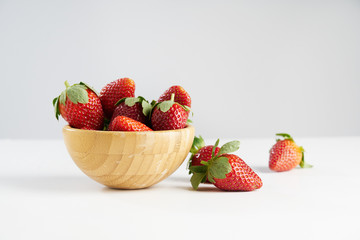 Fresh perfect berries red strawberries in a wooden plate on white, Concept of healthy eat food and nutrition.