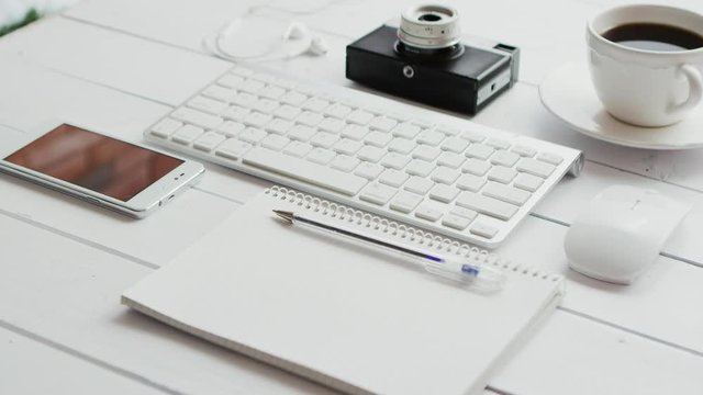 From above view of different office gadgets with photo camera laid near on white background