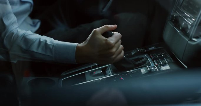 Close up young businessman is driving a new car just bought from auto deal. Slow motion shot in 8K. Concept of passion for driving cars and engines, car dealerships, used cars, luxury cars
