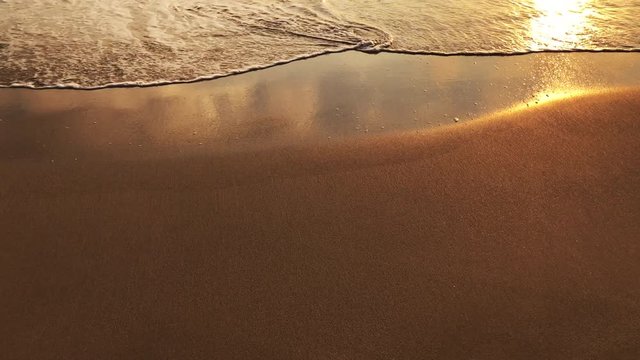 Spring Break message handwritten on the smooth sand of an empty beach with an oncoming wave