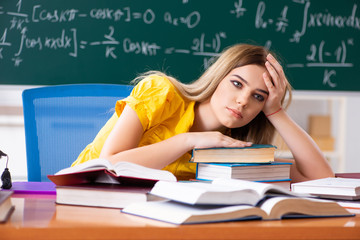 Young female student in front of the chalkboard  