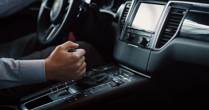 Close up young businessman is driving a new car just bought from auto deal. Slow motion shot in 8K. Concept of passion for driving cars and engines, car dealerships, used cars, luxury cars