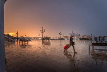 a girl in a hurry on rainy early morning with suitcase