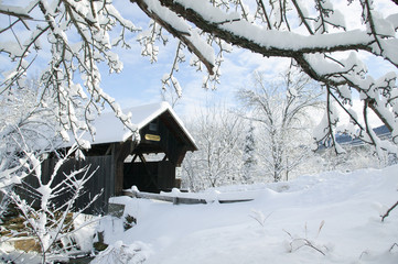 Covered bridged blanketed in fresh snow on a sunny winter morning.