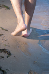 Feet Of Young Man Walking on Beach