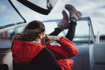 beautiful young woman in a red raincoat rides a private yacht. Stockholm, Sweden © Yuliya Kirayonak
