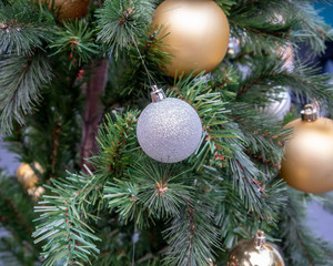 Obraz na płótnie Canvas Hanging shiny silver and golden balls and silver Christmas wreath with tinsel and ornamentsg.