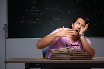 Young male student sitting in classroom