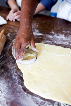 Hand cutting out dough for doughnuts