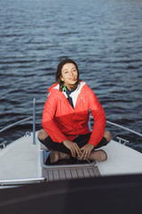 beautiful young woman in a red raincoat rides a private yacht. Stockholm, Sweden