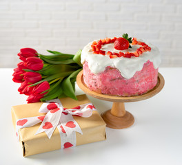 Strawberry cake with gift box and bunch of tulips