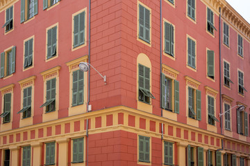 Fototapeta na wymiar Red painted apartment block in Nice, France