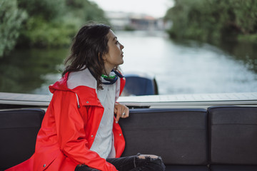 beautiful young woman in a red raincoat rides a private yacht. Stockholm, Sweden © Yuliya Kirayonak