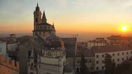 Fototapeta na wymiar Bergamo, Italy. The old town. Aerial view of the Basilica of Santa Maria Maggiore during the sunset. In the background the Po plain