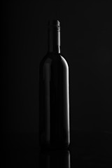 Fototapeta na wymiar Red Wine Bottle on Black Background