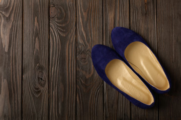 Blue women's shoes (ballerinas) on wooden background.